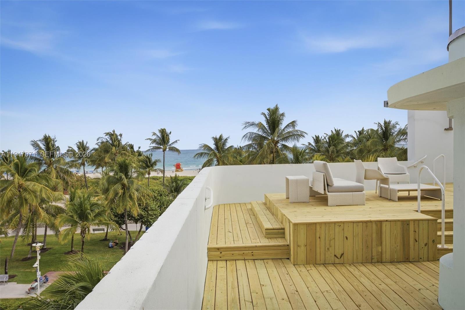 A wooden deck with outdoor seating overlooks a beach with palm trees and the ocean — 1250 Ocean Dr, Miami Beach FL 33139, MIAMI BEACH, FL