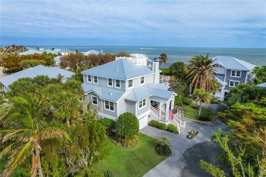 An aerial view of a two-story coastal house with a metal roof and paved driveway — 367 NIGHT HERON DRIVE, BOCA GRANDE, FL