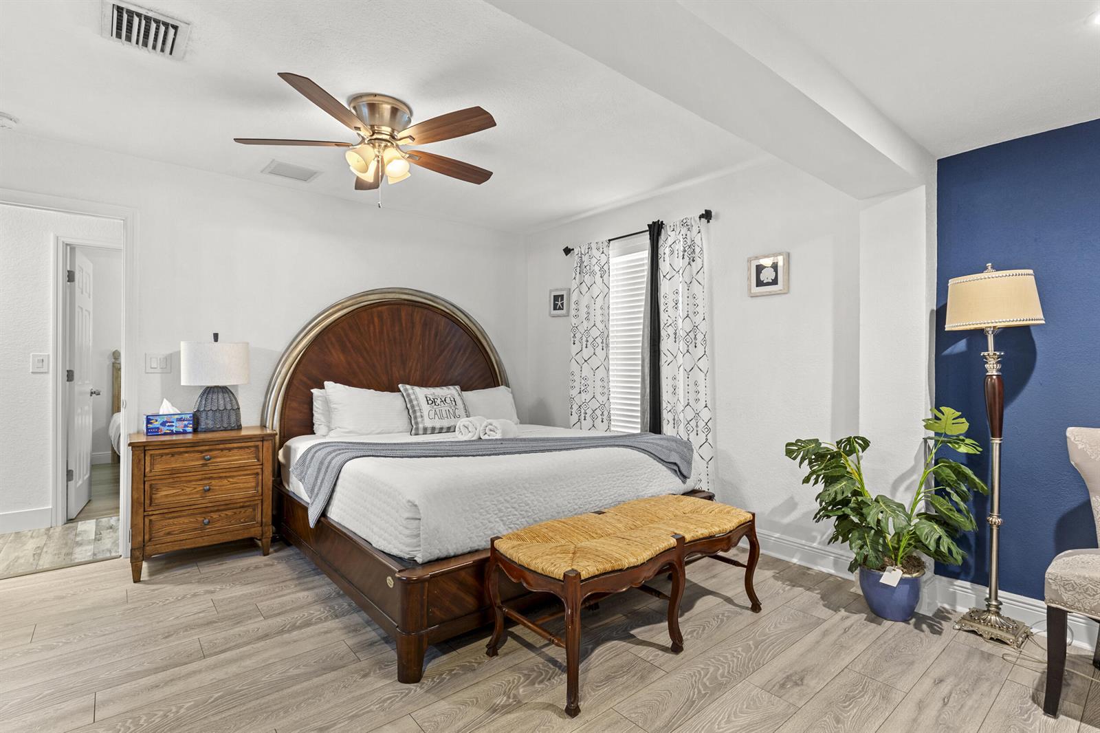 A bedroom features a wooden bed frame, a blue accent wall, and a floor lamp — 944 Hansen Street, West Palm Beach FL 33405, WEST PALM BEACH, FL