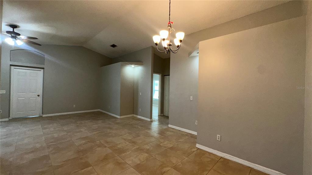 An open-concept living area features vaulted ceilings, tile flooring, and a central chandelier — 2429 SAPIER COURT, ORLANDO, FL