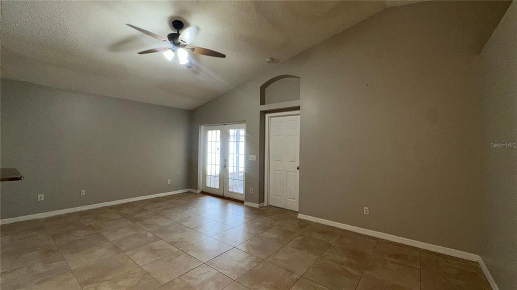 A room with light-colored tile flooring, gray walls, a ceiling fan, and glass doors — 2429 SAPIER COURT, ORLANDO, FL