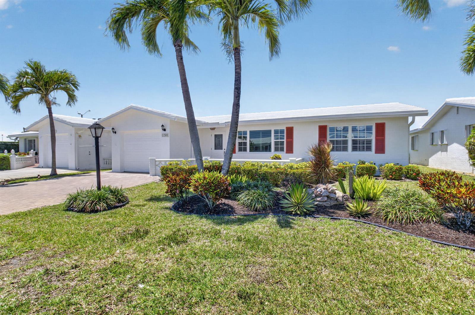 A white single-story house with red shutters and palm trees in the front yard — 1709 SW 20th Street, Boynton Beach FL 33426, BOYNTON BEACH, FL