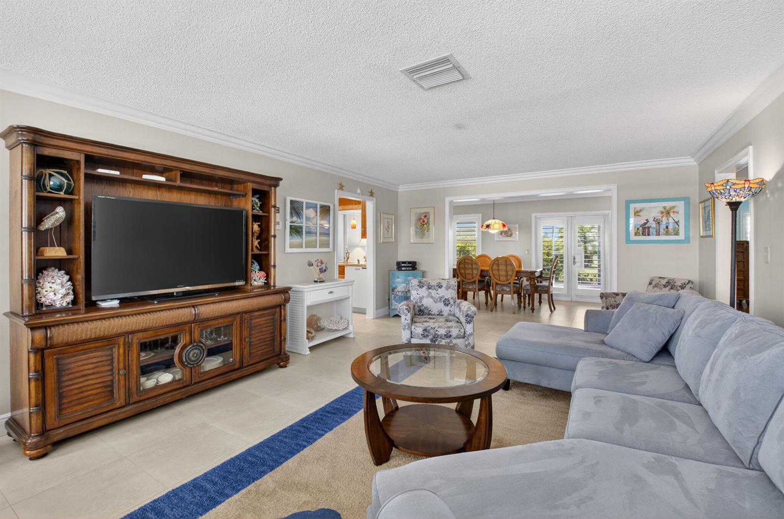 A living room features a large wooden entertainment center, a sectional sofa, and dining area — 1709 SW 20th Street, Boynton Beach FL 33426, BOYNTON BEACH, FL