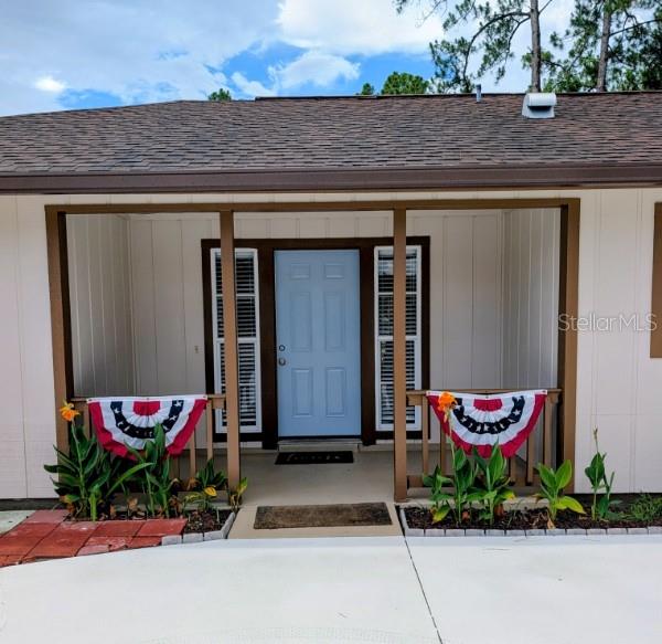 The exterior of a house features a covered porch with a light blue front door — 3331 TRAVERSE AVENUE, NORTH PORT, FL