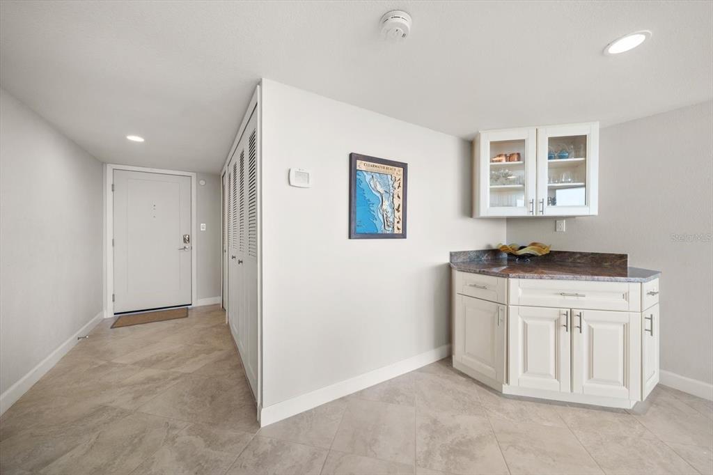 A white entryway features a wet bar with granite countertops and a framed map — 400 ISLAND WAY UNIT 901, CLEARWATER BEACH, FL