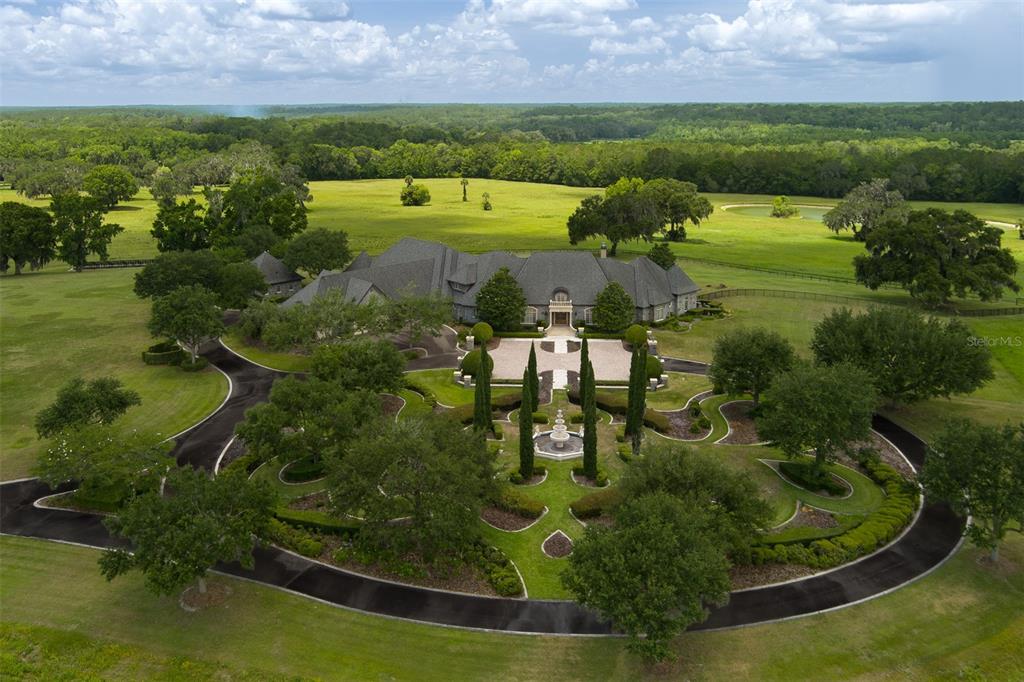 An aerial view shows a large house with a circular driveway and landscaped gardens — 9095 NW 200TH STREET ROAD, MICANOPY, FL