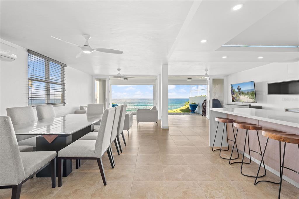 A bright, open-concept dining and kitchen area features tile floors and views of the ocean — J1 CALLE COSTA DORADA, DORADO, PR