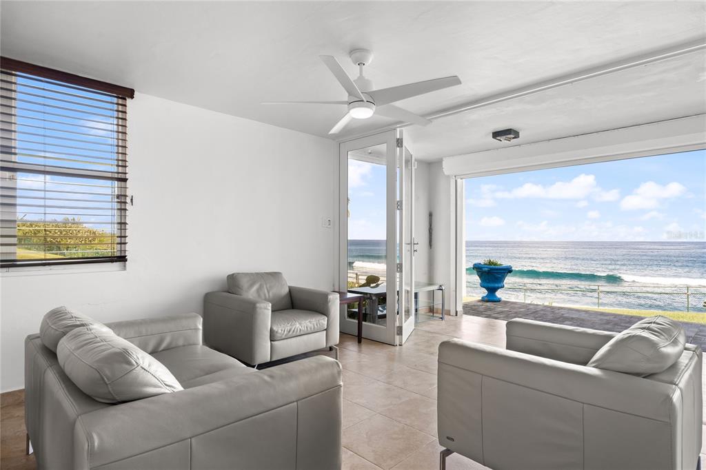 A living room with light gray leather furniture, a ceiling fan, and ocean views — J1 CALLE COSTA DORADA, DORADO, PR