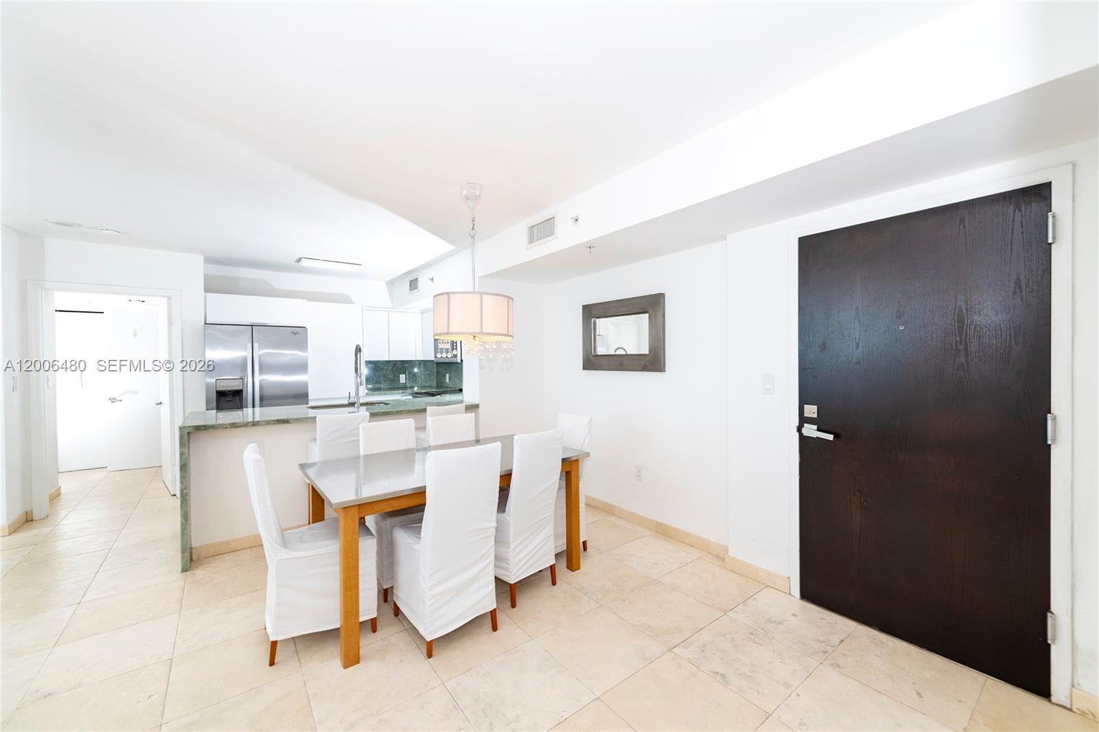 A modern living room features a grey sectional sofa, a patterned rug, and a balcony view — 90 Alton Rd # 2304, Miami Beach FL 33139, MIAMI BEACH, FL
