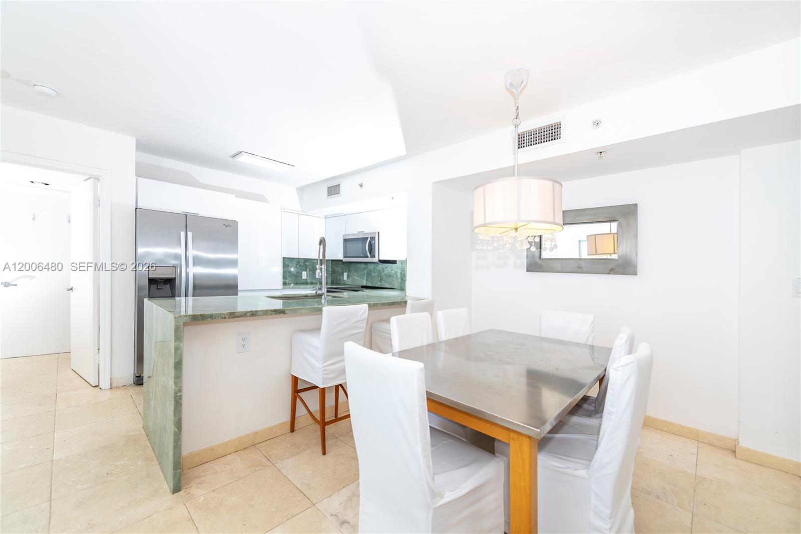 A living room features a white sectional sofa, a patterned rug, and a balcony view — 90 Alton Rd # 2304, Miami Beach FL 33139, MIAMI BEACH, FL
