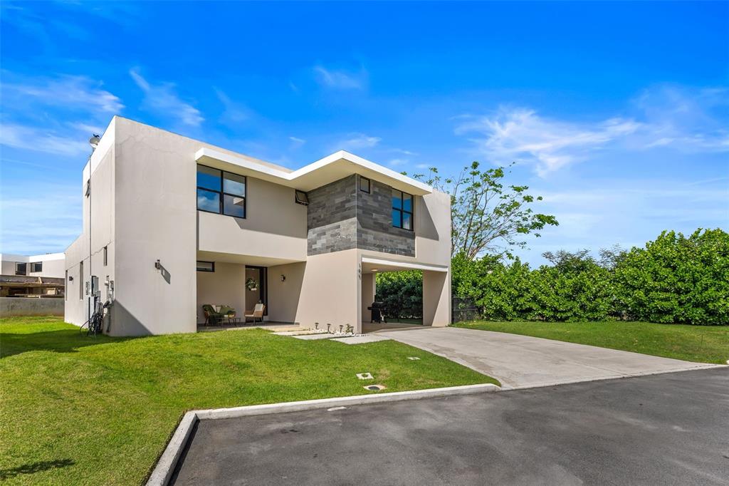 A two-story modern house with a concrete driveway, a covered carport, and a grassy lawn — 109 CALLE DANUBIO, GURABO, PR