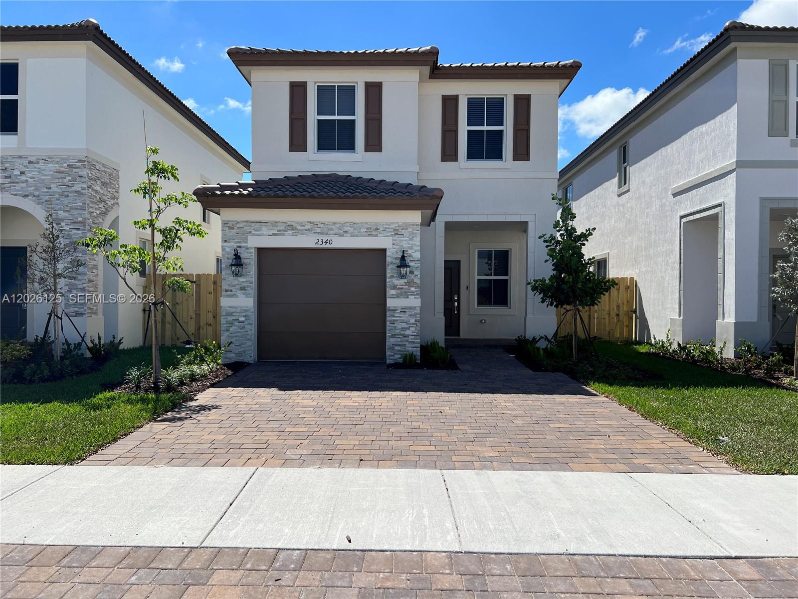 A two-story house with a stone-accented garage, brown shutters, and a paved driveway — 2340 NW 130 Terrace, Miami FL 33167, MIAMI, FL
