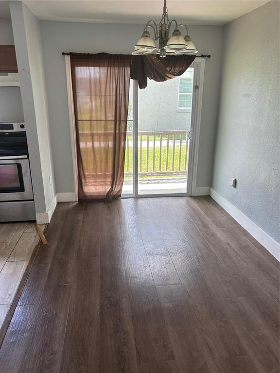 A dining area features wood-look flooring, a chandelier, and a sliding glass door with curtains — 2779 L B MCLEOD ROAD UNIT A, ORLANDO, FL