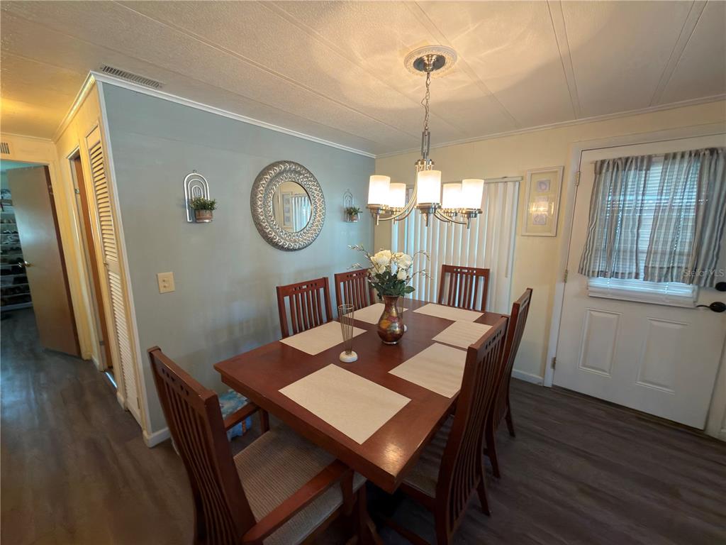 A dining room features a wooden table with six chairs under a chandelier — 2055 S FLORAL AVENUE UNIT 42, BARTOW, FL