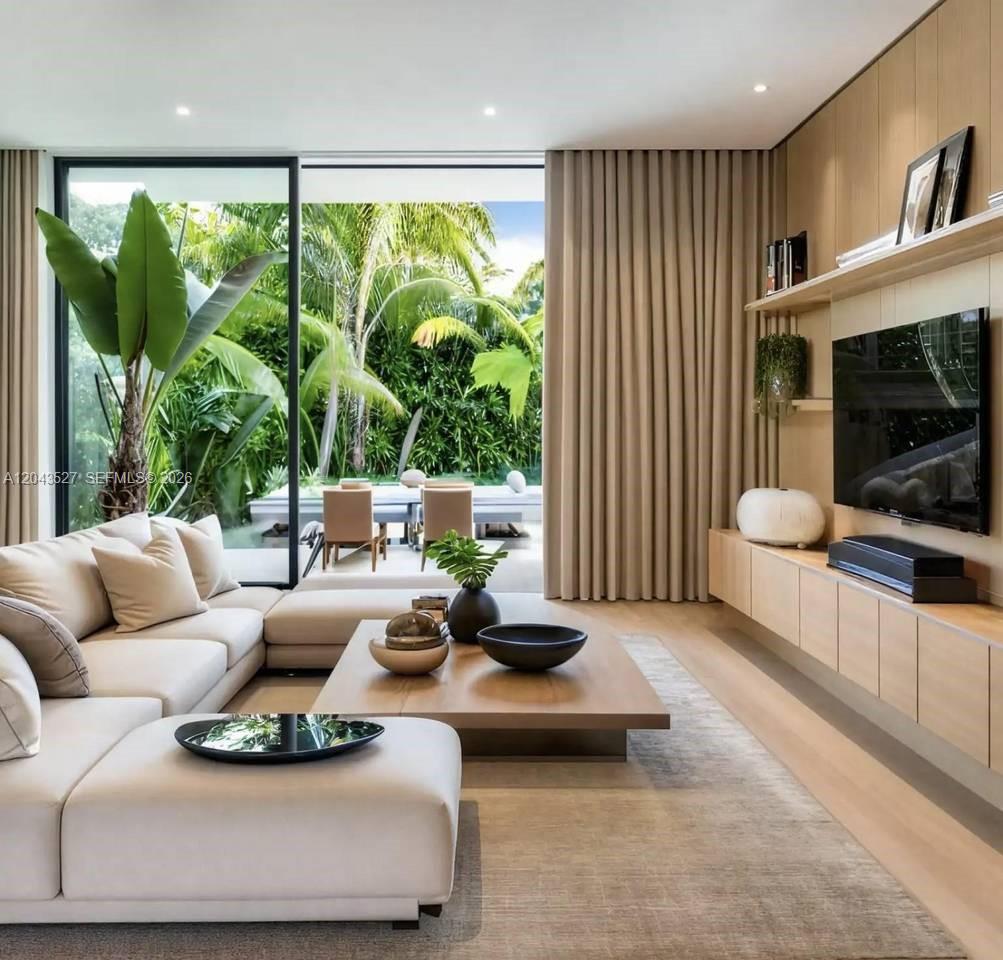 A modern living room features a sectional sofa, wood cabinetry, and floor-to-ceiling windows overlooking greenery — 0 villa bekasi, FL