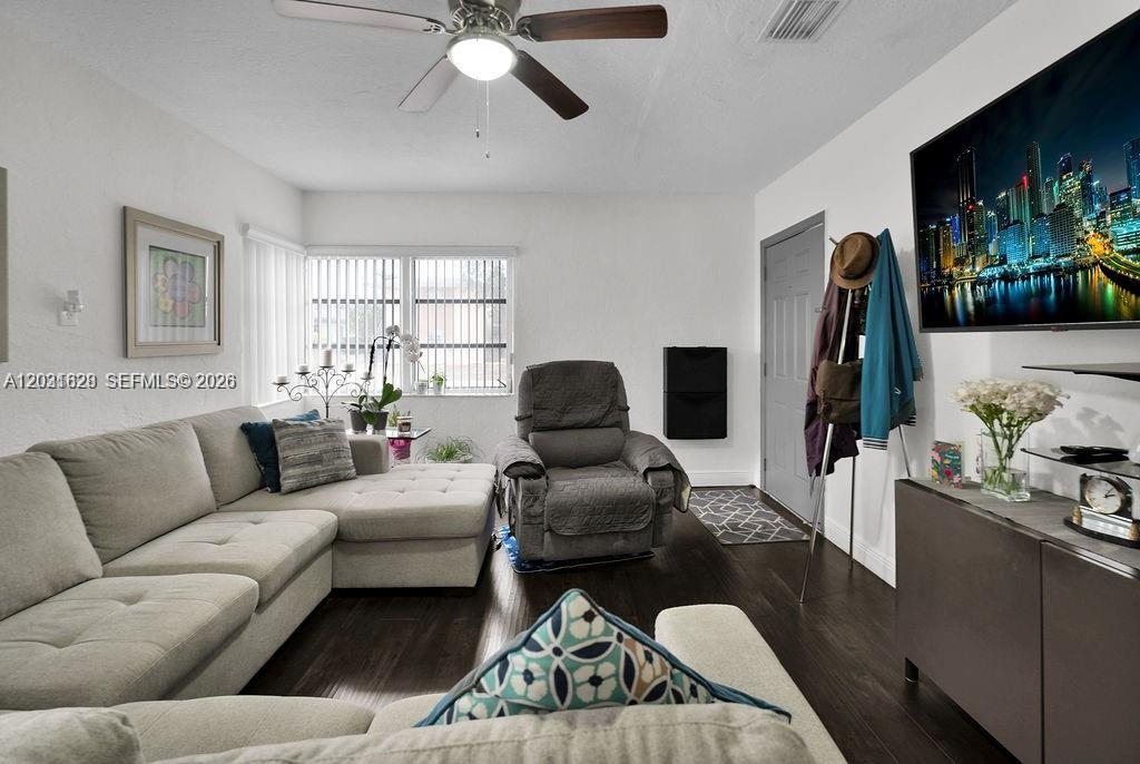 A living room features a gray sectional sofa, a recliner, and a wall-mounted television — 600 NW 34th Ave, Miami FL 33125, MIAMI, FL
