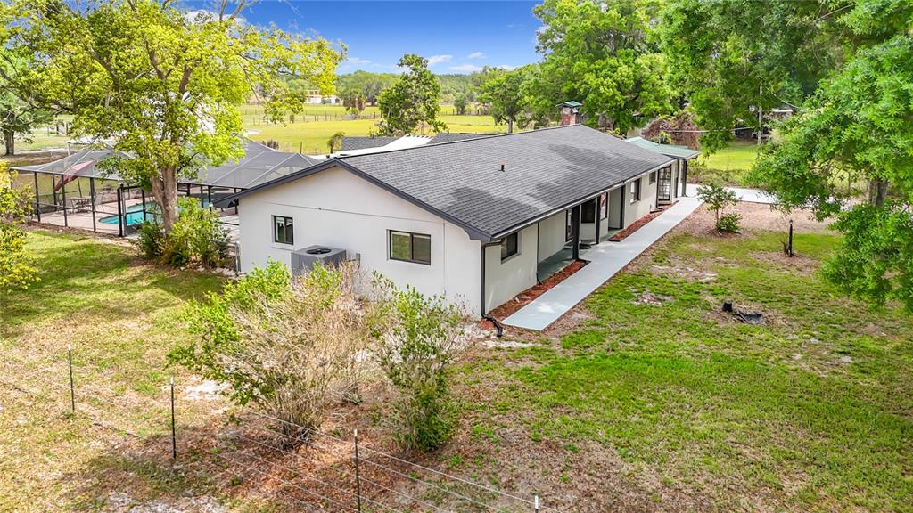 An aerial view of a single-story house with a screened pool and a large yard — 216 CORBETT ROAD, LITHIA, FL
