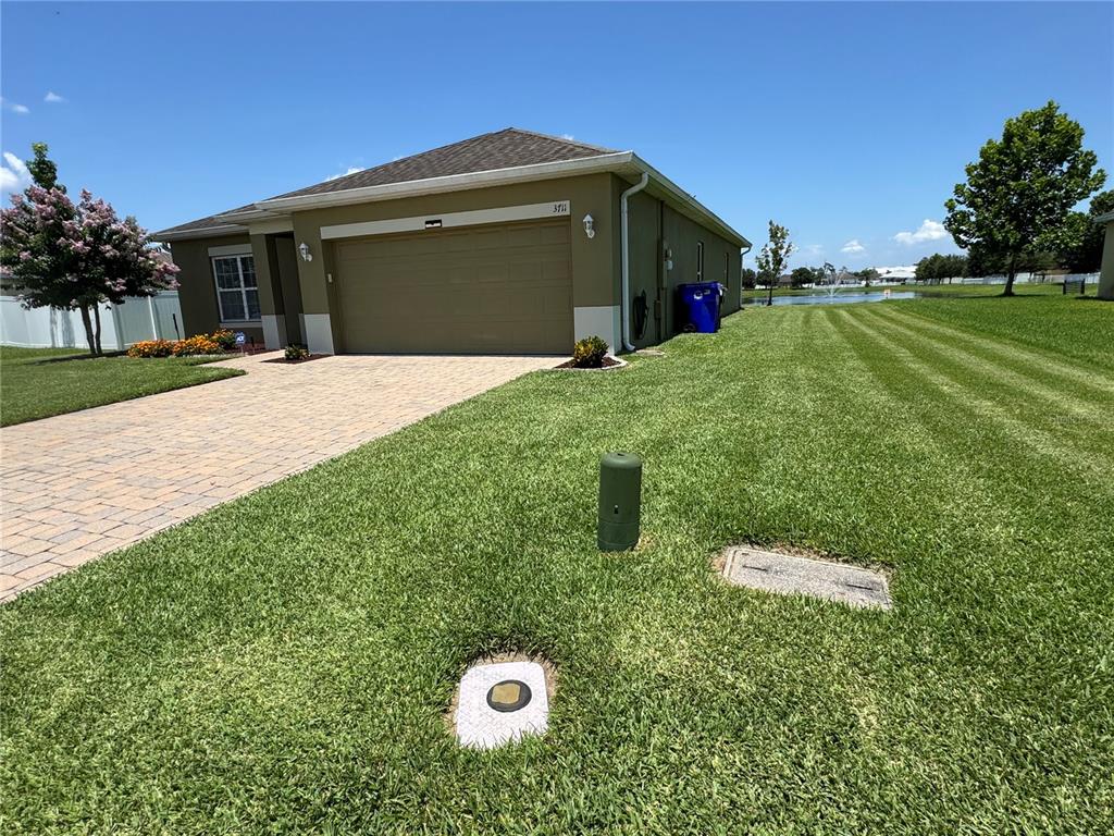 A single-story house with a tan exterior, a two-car garage, and a paved driveway — 3711 BRIARWOOD ESTATES CIRCLE, ST CLOUD, FL