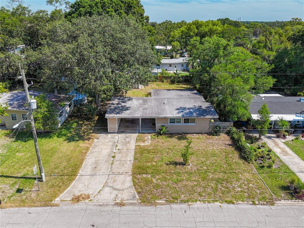 An aerial view shows a single-story house with a flat roof, carport, and concrete driveway — 7615 MAYAPPLE ROAD, JACKSONVILLE, FL