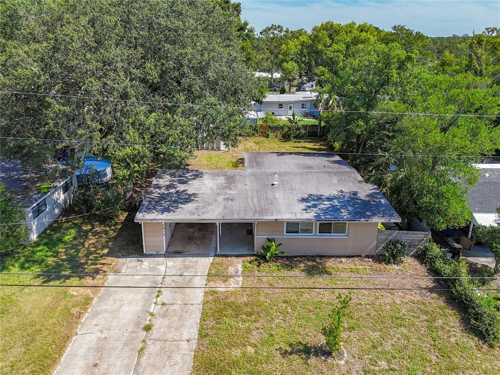 An aerial view shows a single-story house with a carport and a concrete driveway — 7615 MAYAPPLE ROAD, JACKSONVILLE, FL