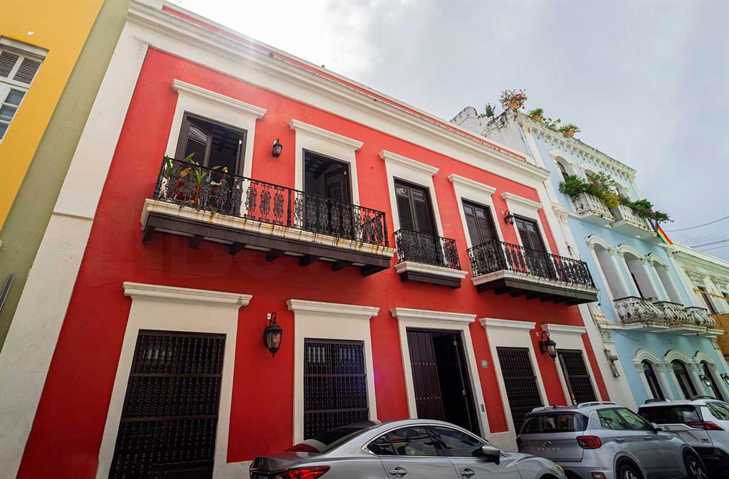 A bright red two-story colonial building with black iron balconies and dark wooden doors — 153 SAN JUSTO, SAN JUAN, PR