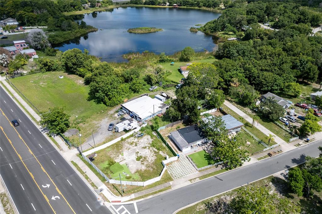 An aerial view shows a commercial building and a house near a lake — 6011 OLD WINTER GARDEN ROAD, ORLANDO, FL