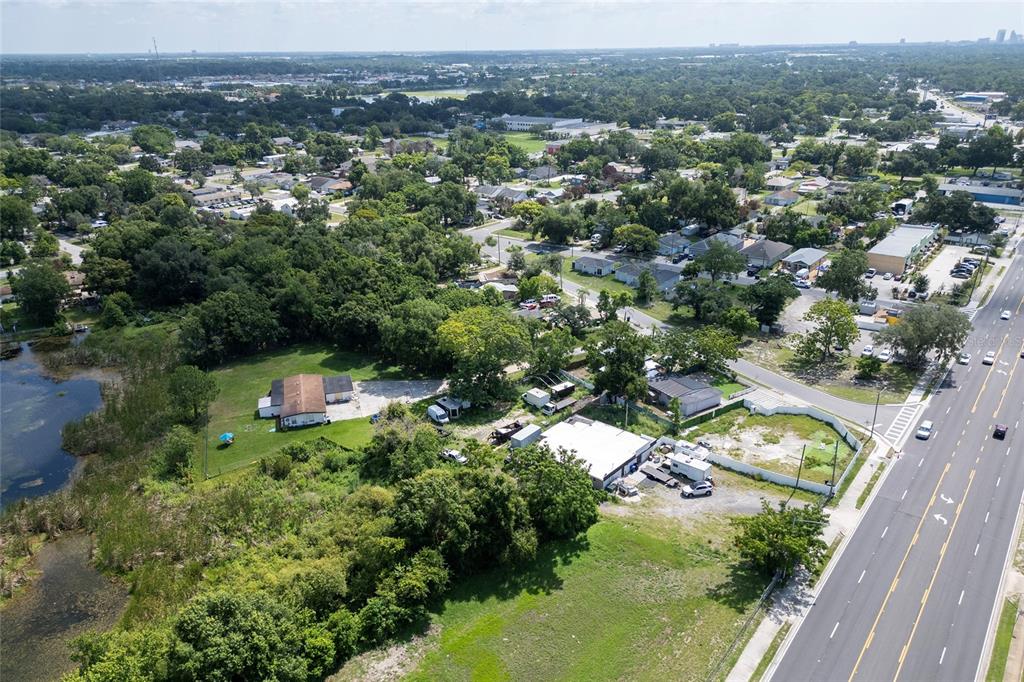 An aerial view shows a commercial property with buildings and parking adjacent to a road — 6011 OLD WINTER GARDEN ROAD, ORLANDO, FL