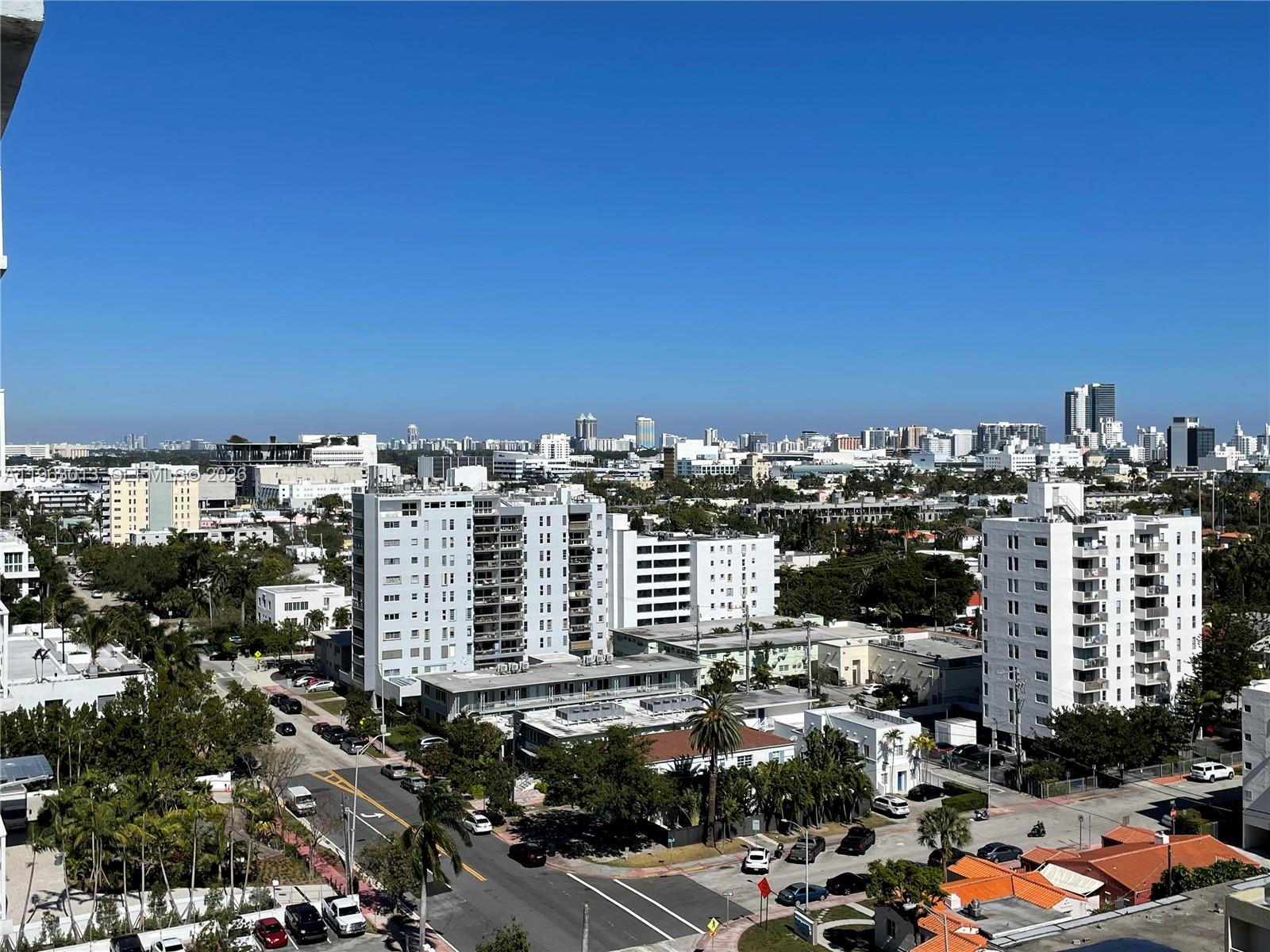 An elevated view of a city neighborhood featuring apartment buildings, streets, and palm trees — 1200 West Ave # 1418, Miami Beach FL 33139, MIAMI BEACH, FL