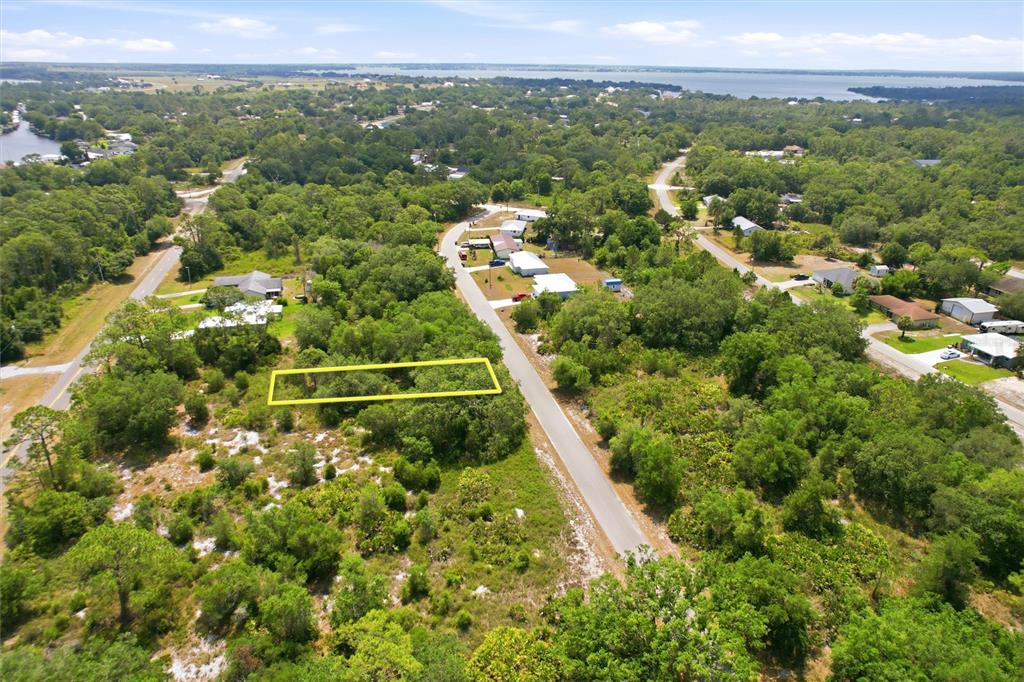 An aerial view shows a rectangular vacant lot outlined in yellow along a paved road — 3392 GOSSAMER AVENUE, LAKE PLACID, FL