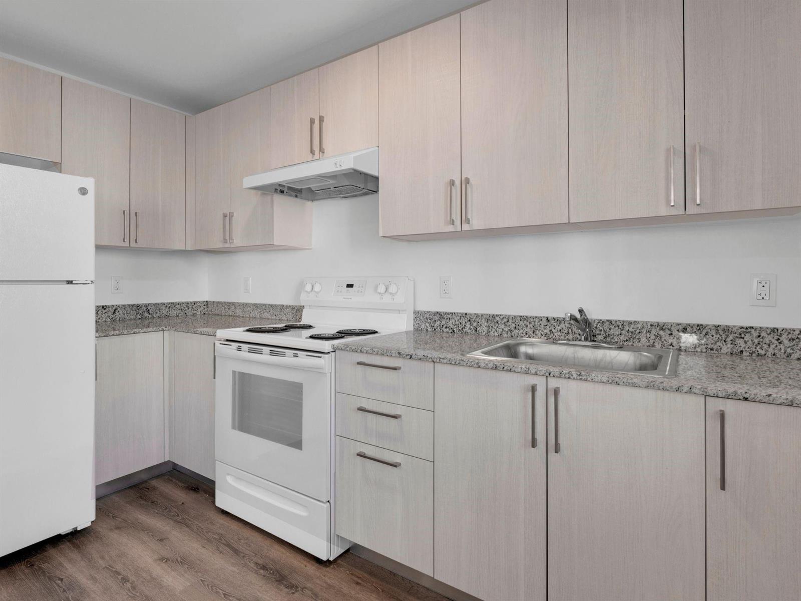 A kitchen with light wood cabinets, granite countertops, a white stove, and a stainless steel sink — 2130 NW 37th Street, Miami FL 33142, MIAMI, FL
