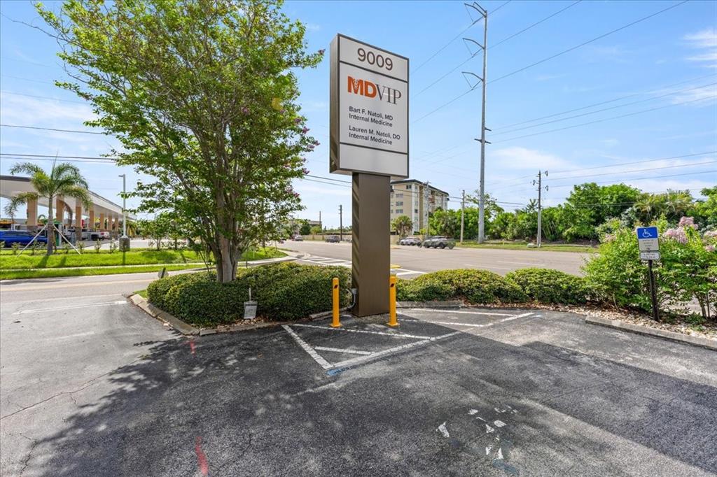 A tall, rectangular medical office sign stands in a paved parking lot near a road — 9009 PARK BOULEVARD UNIT Suite B, SEMINOLE, FL