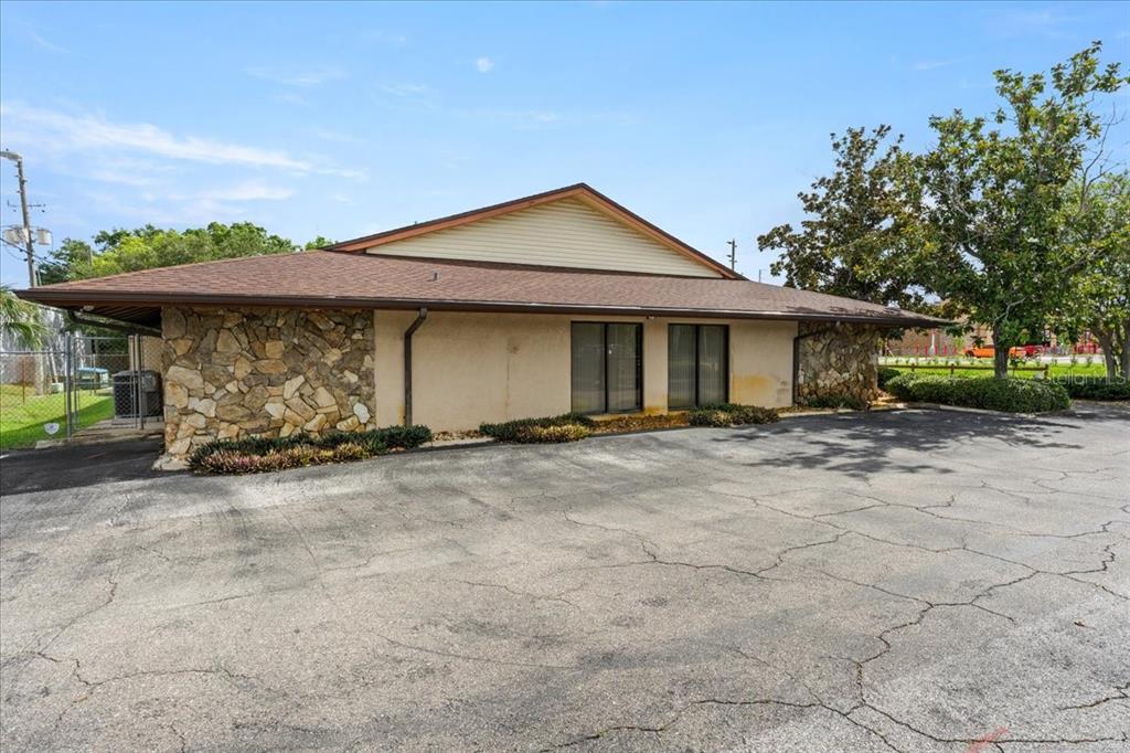 A single-story commercial building features a stone facade, brown roof, and a cracked asphalt parking lot — 9009 PARK BOULEVARD UNIT Suite B, SEMINOLE, FL