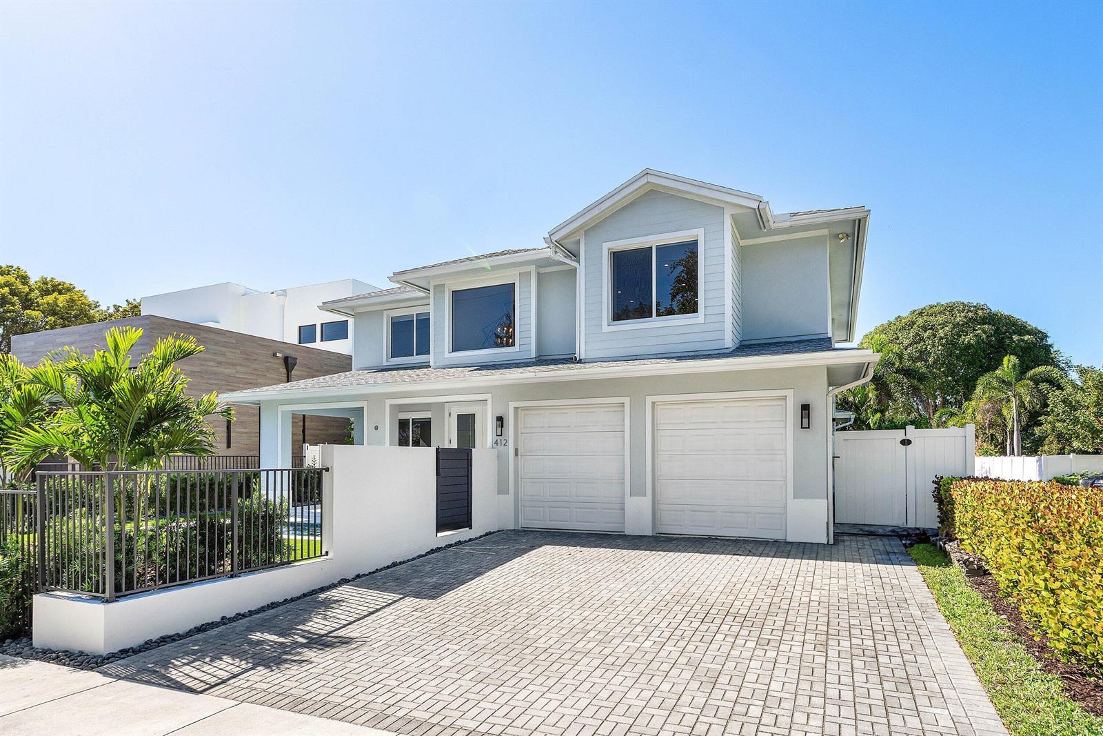 A two-story house with light blue siding, a two-car garage, and a paved driveway — 412 SE 4th Avenue, Delray Beach FL 33483, DELRAY BEACH, FL