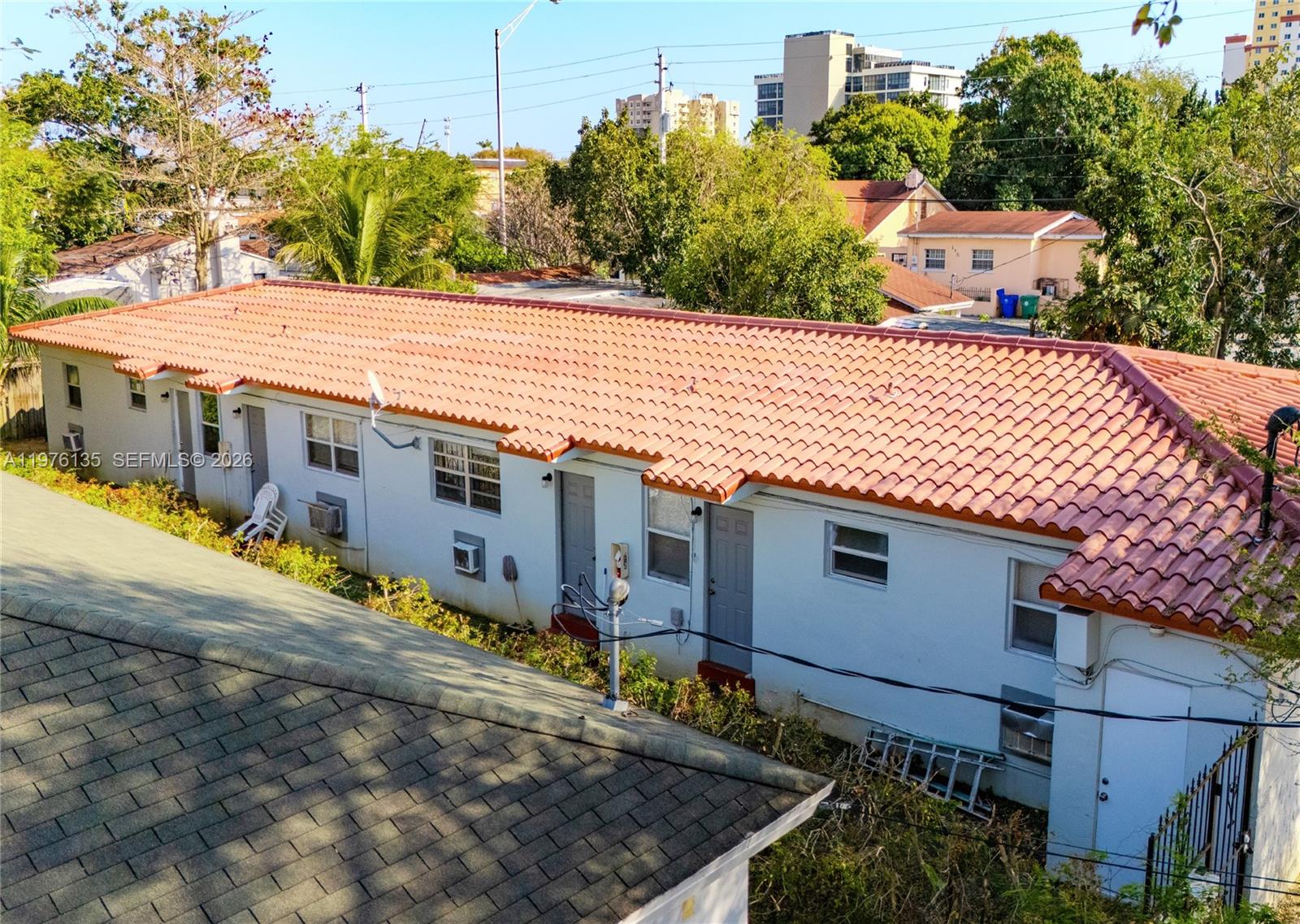 An exterior view of a single-story apartment building with a terracotta tile roof — 8213 NE 1st Ave, Miami FL 33138, MIAMI, FL