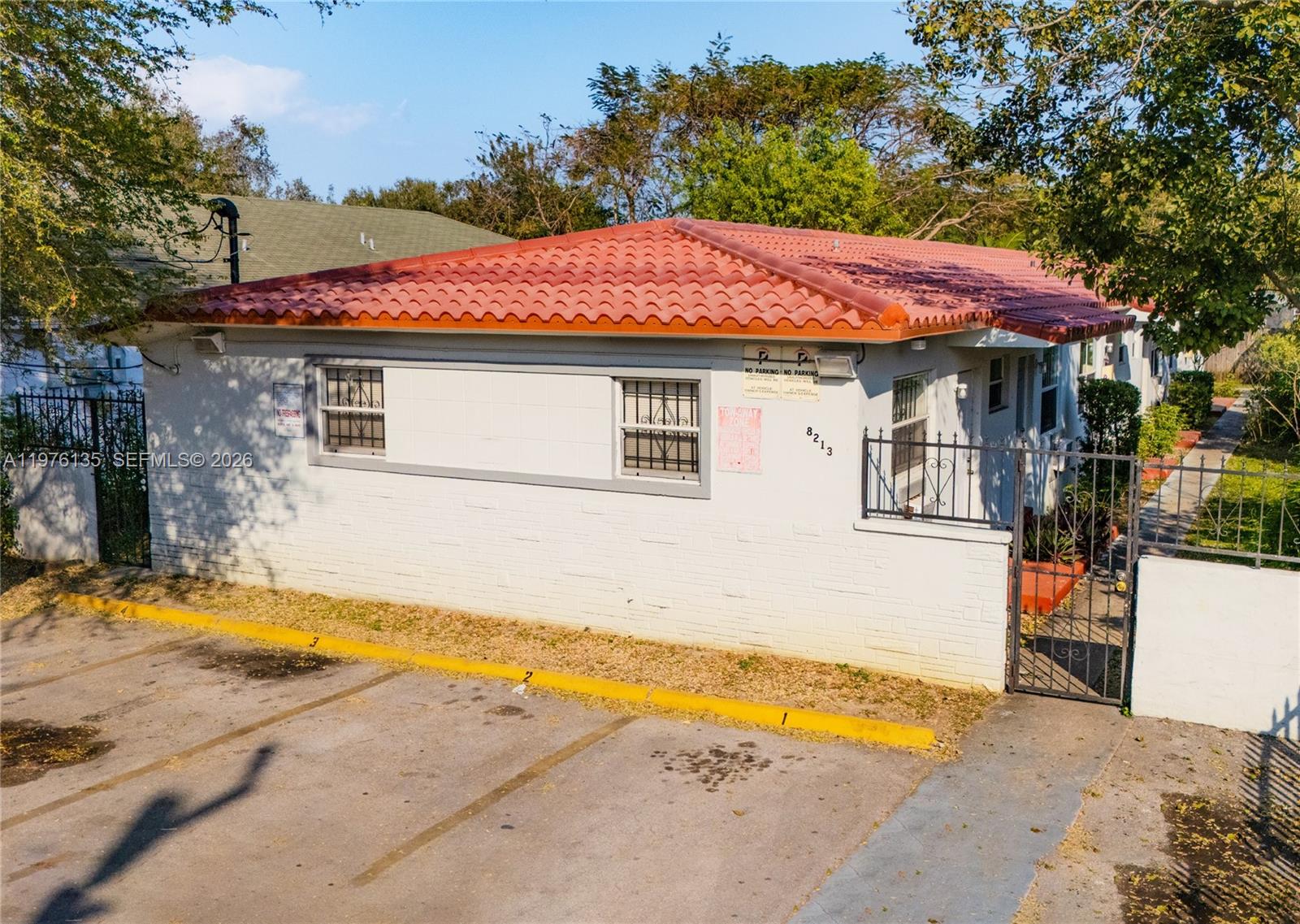 A single-story white building with a red tile roof and a paved parking area — 8213 NE 1st Ave, Miami FL 33138, MIAMI, FL