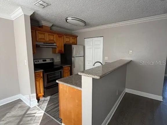 A kitchen features wood cabinets, stainless steel appliances, and a granite-topped breakfast bar — 7298 ULMERTON ROAD UNIT 605, LARGO, FL