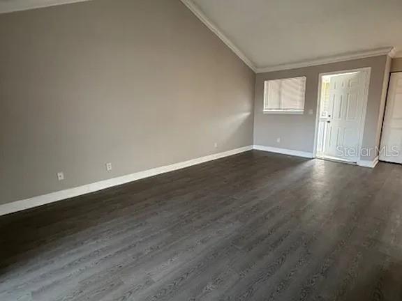 An empty living room with gray walls, vaulted ceilings, and dark wood-look flooring — 7298 ULMERTON ROAD UNIT 605, LARGO, FL
