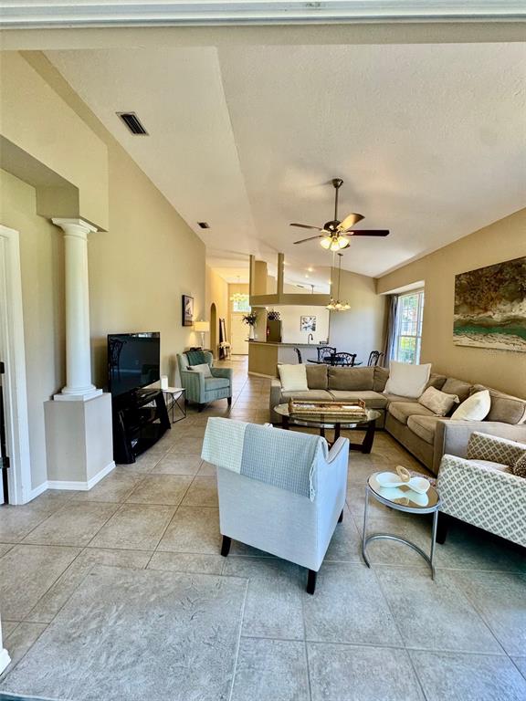 A living room features tile flooring, a beige sectional sofa, and a ceiling fan — 7330 KENSINGTON COURT, BRADENTON, FL