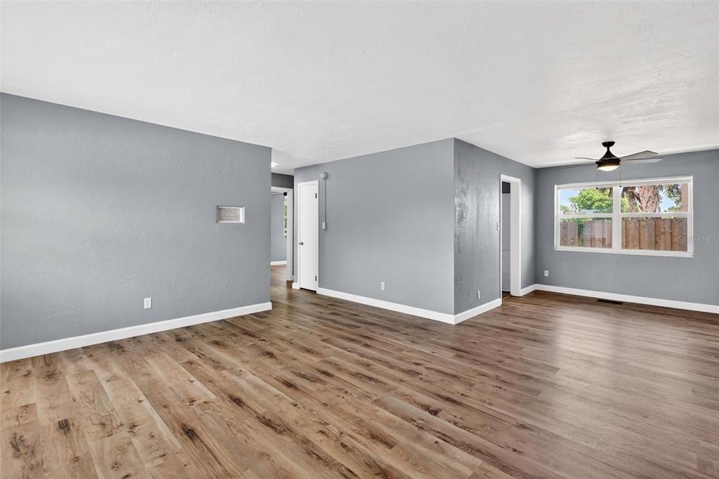 An empty room with gray walls, wood-look flooring, a ceiling fan, and a window — 419 N PENINSULA DRIVE, DAYTONA BEACH, FL