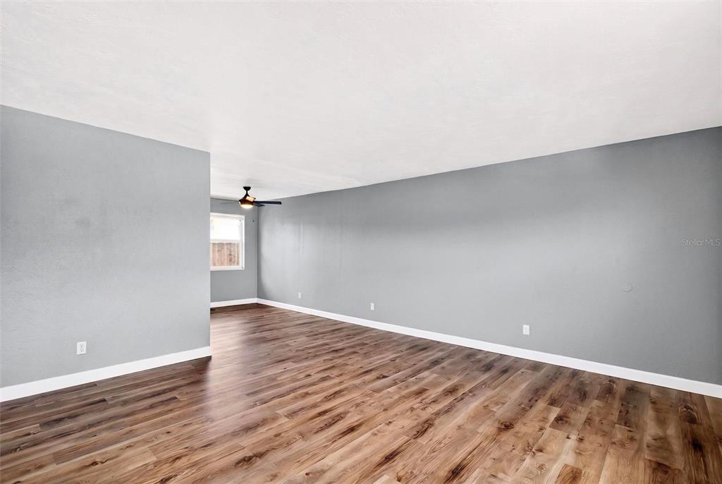 An empty room with gray walls, white trim, and wood-look flooring — 419 N PENINSULA DRIVE, DAYTONA BEACH, FL