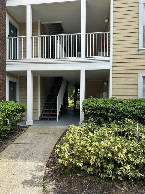 An exterior view of a two-story apartment building with a staircase and covered walkways — 10024 STRAFFORD OAK COURT UNIT 803, TAMPA, FL