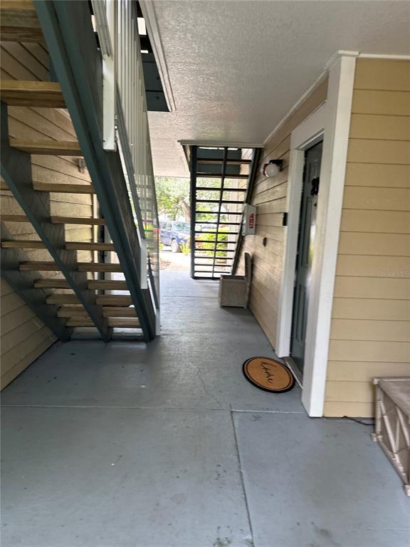 An outdoor apartment stairwell features a metal staircase, a front door, and a welcome mat — 10024 STRAFFORD OAK COURT UNIT 803, TAMPA, FL