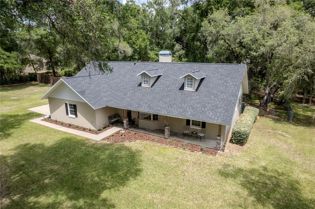 An aerial view of a single-story house with a gray shingled roof and dormer windows — 26 COUNT FLEET DRIVE, OCALA, FL