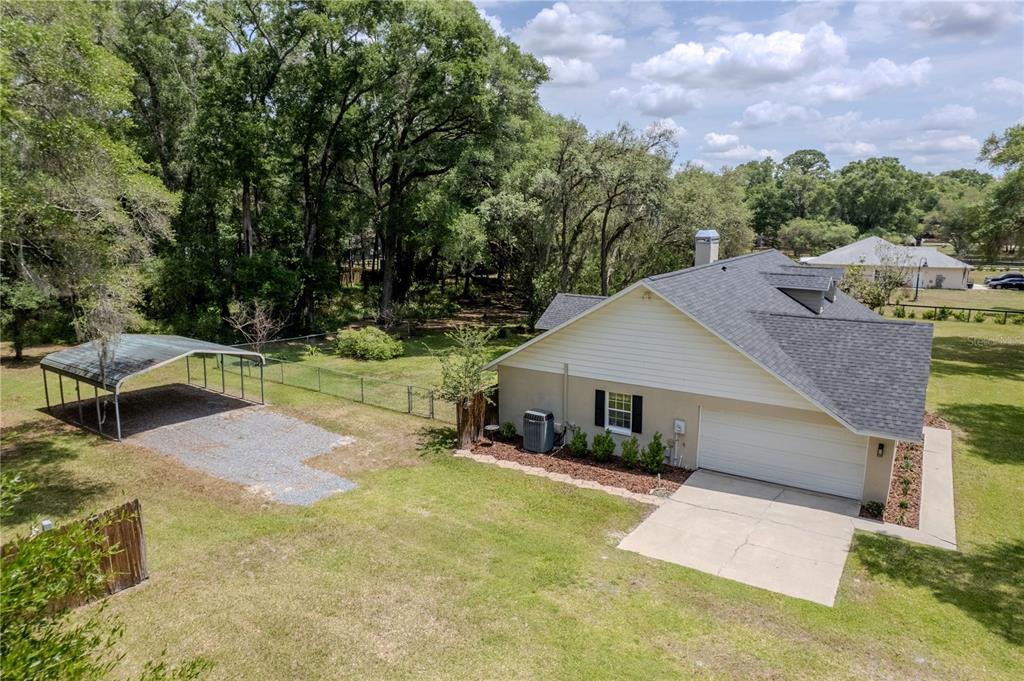 An aerial view shows a house with a garage, a carport, and a fenced backyard — 26 COUNT FLEET DRIVE, OCALA, FL