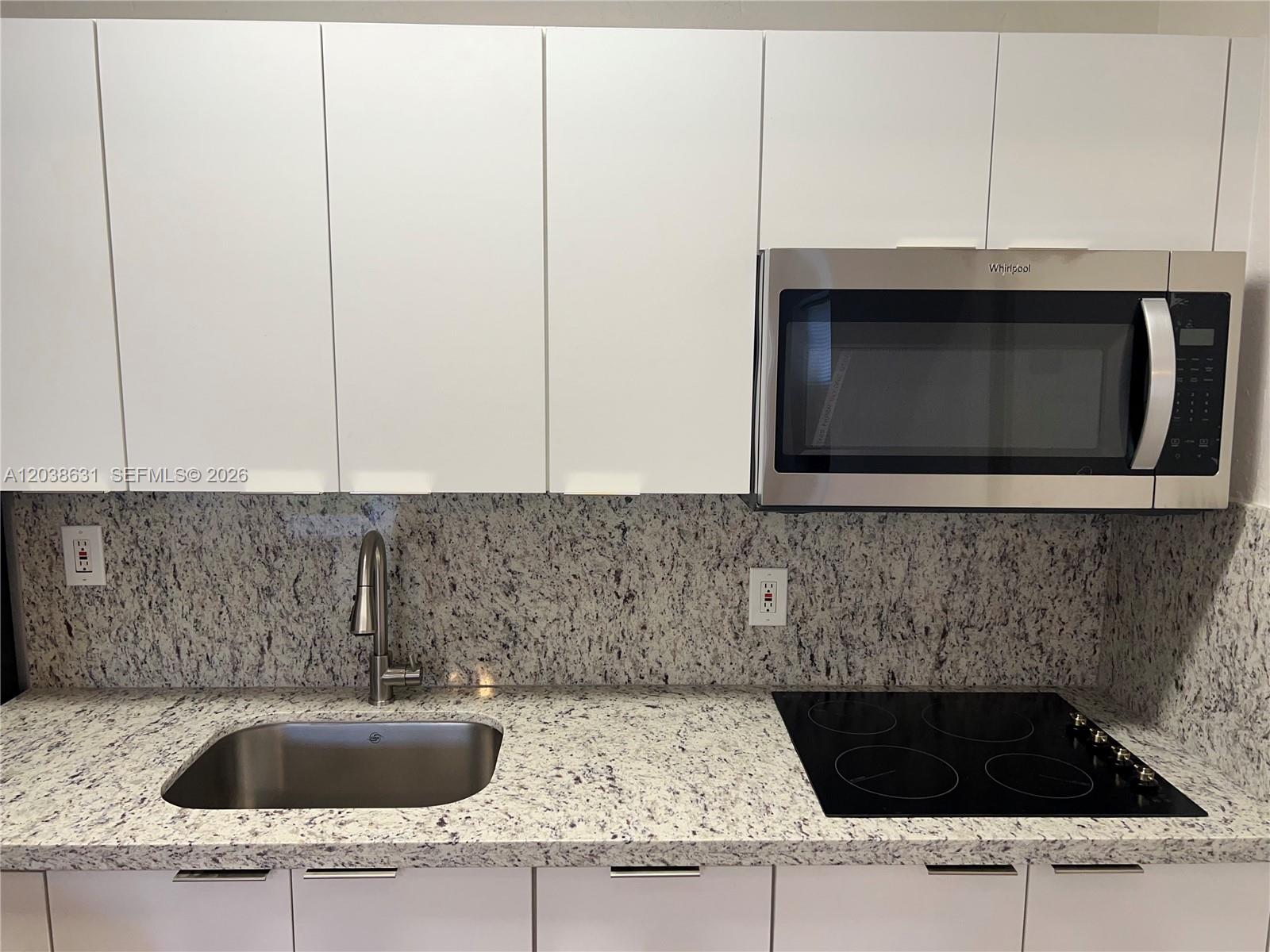 A kitchen features white cabinets, a granite countertop, a stainless steel sink, and a microwave — 361 Sharar Ave # 6, Opa-Locka FL 33054, OPA-LOCKA, FL