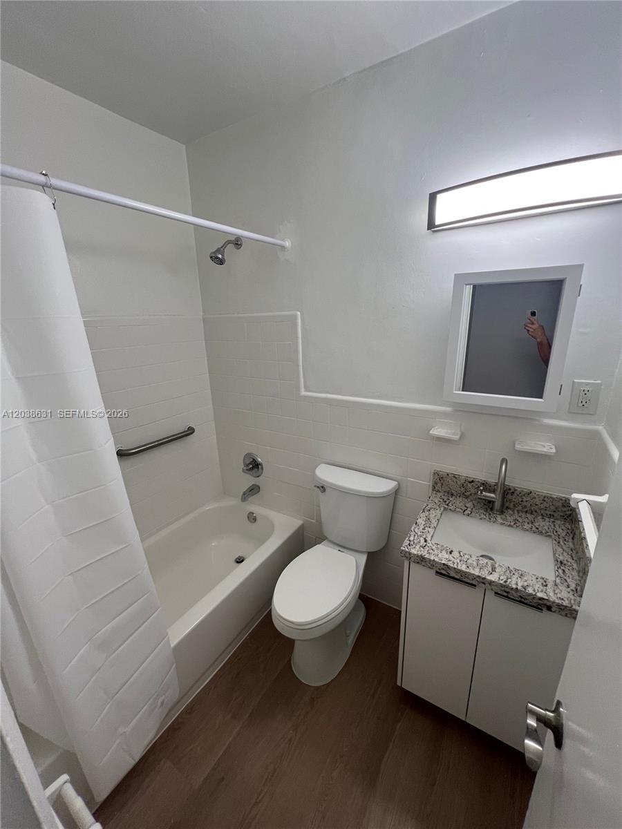 A small bathroom features a white tub-shower combo, a toilet, and a granite-topped vanity — 361 Sharar Ave # 6, Opa-Locka FL 33054, OPA-LOCKA, FL