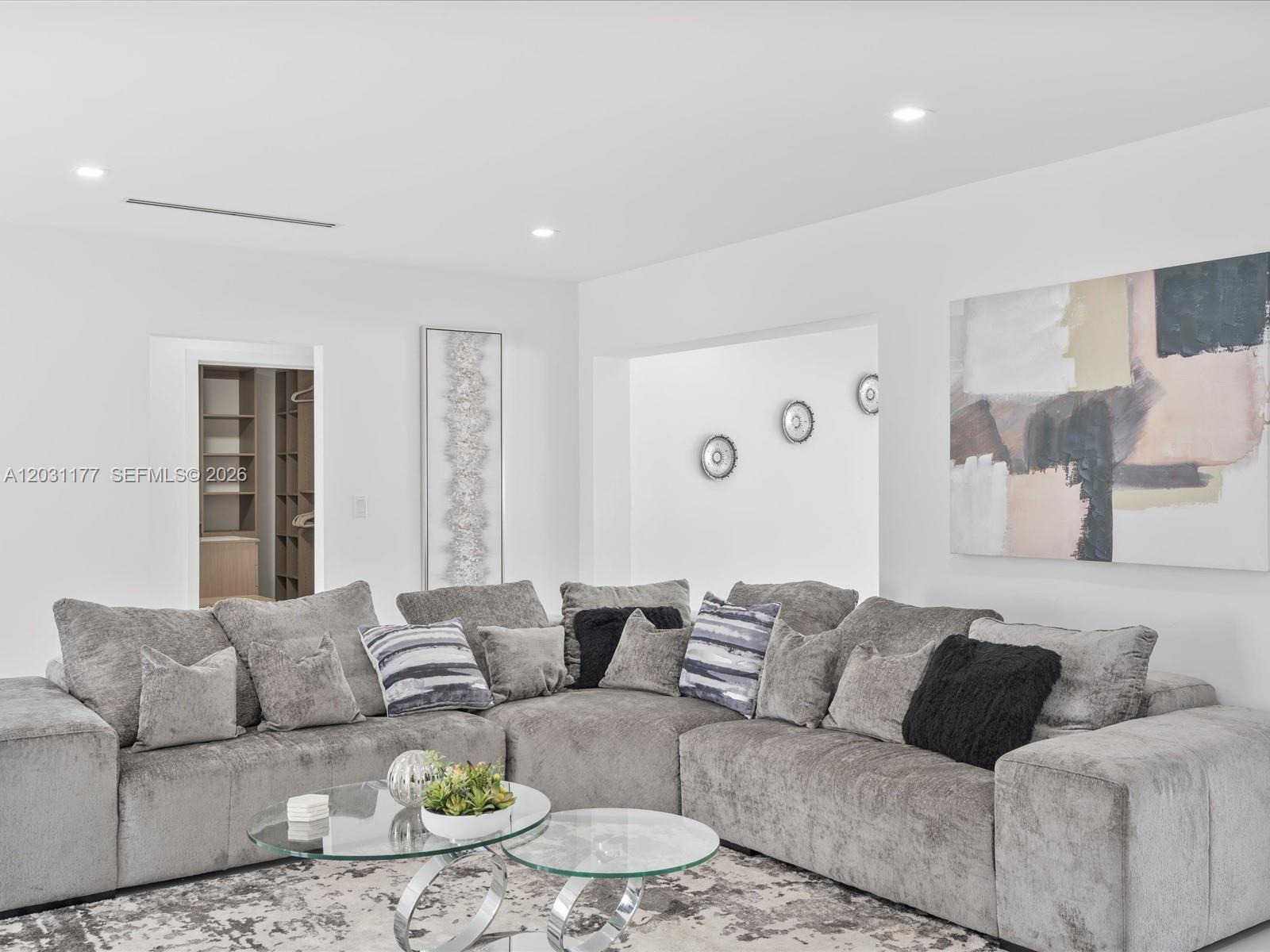 A living room features a large gray sectional sofa, glass coffee tables, and abstract wall art — 4901 Grant St, Hollywood FL 33021, HOLLYWOOD, FL