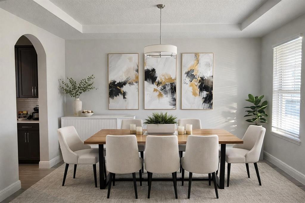 A dining room features a wooden table, six upholstered chairs, and three abstract wall paintings — 8768 SONOMA COAST DRIVE, WINTER GARDEN, FL