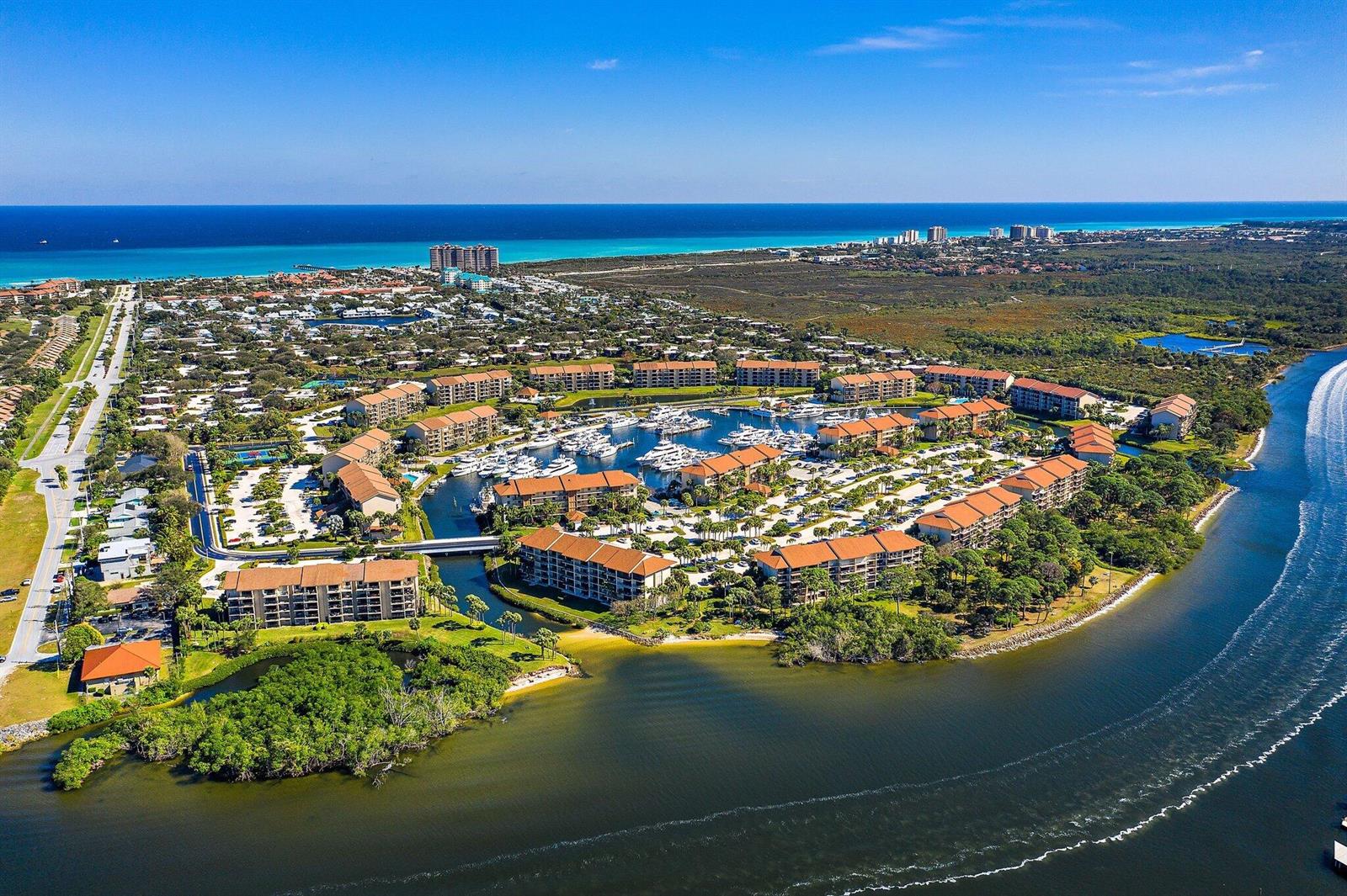 Aerial view of a waterfront residential complex with a central marina and surrounding buildings — 2601 Marina Isle Way # 402, Jupiter FL 33477, JUPITER, FL