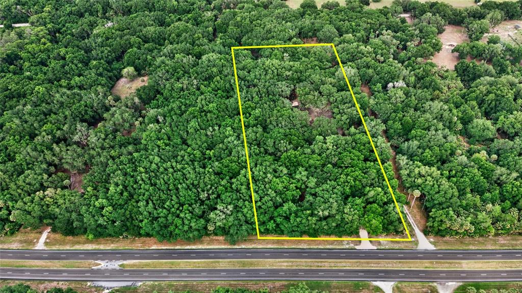 An aerial view shows a rectangular plot of land outlined in yellow bordering a highway — 0 N US HWY 301, CITRA, FL